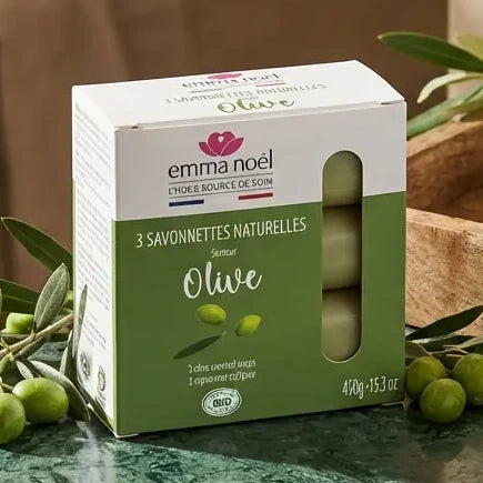 Savonnettes olive bio Emma Noël 3x150g sur vanité avec branches d'olivier et accessoires spa