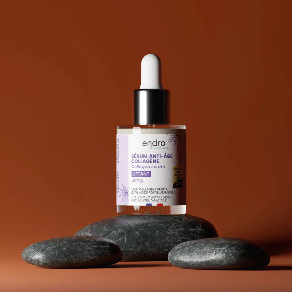 Un flacon de sérum anti-âge de la marque Endro posé sur des galets