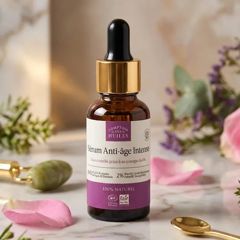 Sérum Anti-âge Intense 30ml Comptoir des Huiles sur marbre avec fleurs et accessoires beauté