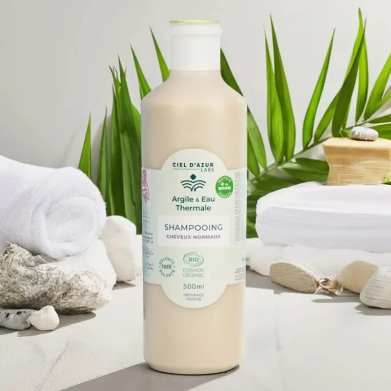 Photo d'ambiance d'une bouteille de Shampoing de 500ml de shampoing pour cheveux normaux de la marque Argile & Eau Thermale 