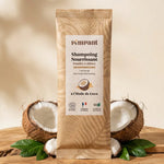 Shampoing en poudre Pimpant coco 25g entouré de noix de coco et feuilles vertes sur bois