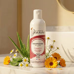 Shampoing bio Les Couleurs de Jeanne 230ml sur marbre avec fleurs botaniques