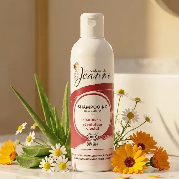 Shampoing bio Les Couleurs de Jeanne 230ml sur marbre avec fleurs botaniques