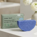 Shampoing solide blond aux pigments bleu ultramarine Comme Avant sur vanité avec fleurs blanches