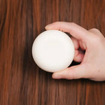 un shampoing solide dans les mains d'une personne 