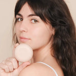 Une femme tenant un shampoing solide pour cheveux secs de la marque Endro