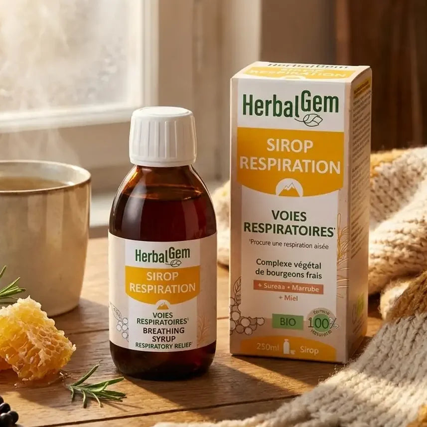Sirop Respiration bio HerbalGem 250 ml sur une table de cuisine d'hiver, avec thé chaud, miel, romarin et sureau