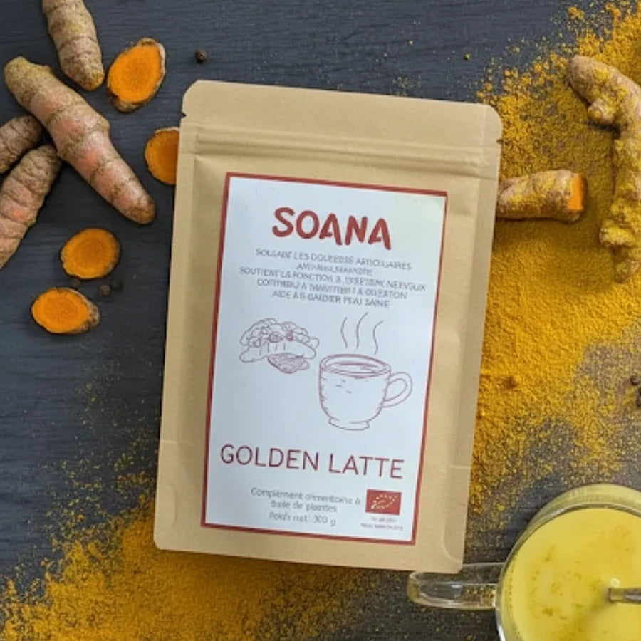 Sachet de 100 g de golden latte de la marque Soana sur un lit d'epices de curcuma et de gingembre