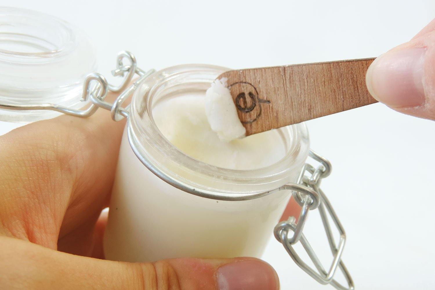 Zoom sur une Une Petite spatule en bois de 6 cm de la marque Endro en train d'être utilisé pour prélevé de la crème hydratante