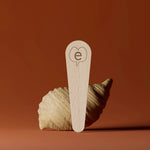 Une spatule en bois de la marque Endro devant un coquillage