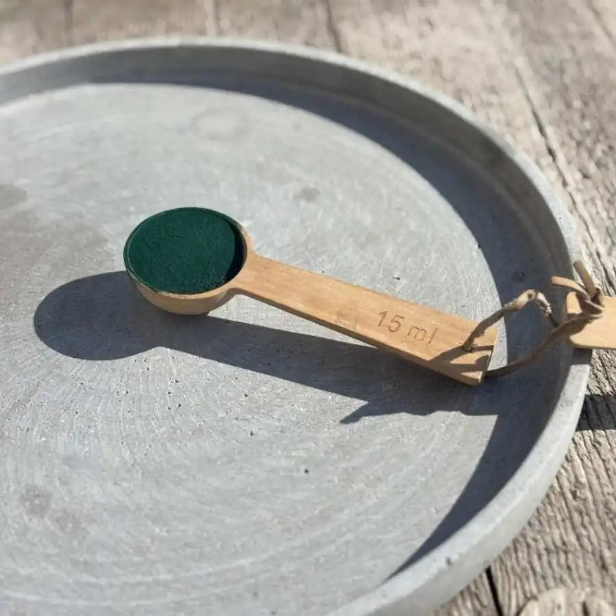 Une cuillère en bois remplie de Spiruline bio en poudre origine France de la marque Etika Spirulina