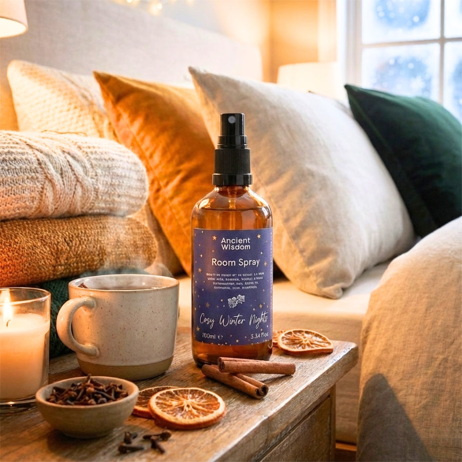 un spray d'ambiance brume d'oreiller ancient de la marque ancient wisdom parfum cosy winter nights avec une tasse de thé et des épices dans une chambre