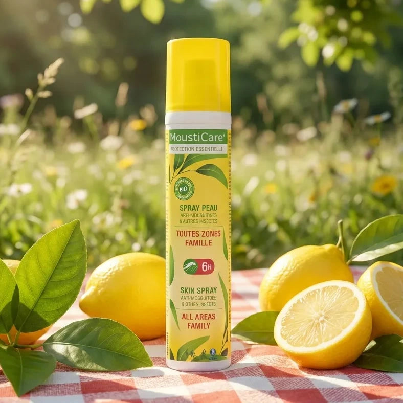 Spray anti-moustique MoustiCare 125ml famille sur couverture pique-nique avec citrons et feuilles vertes