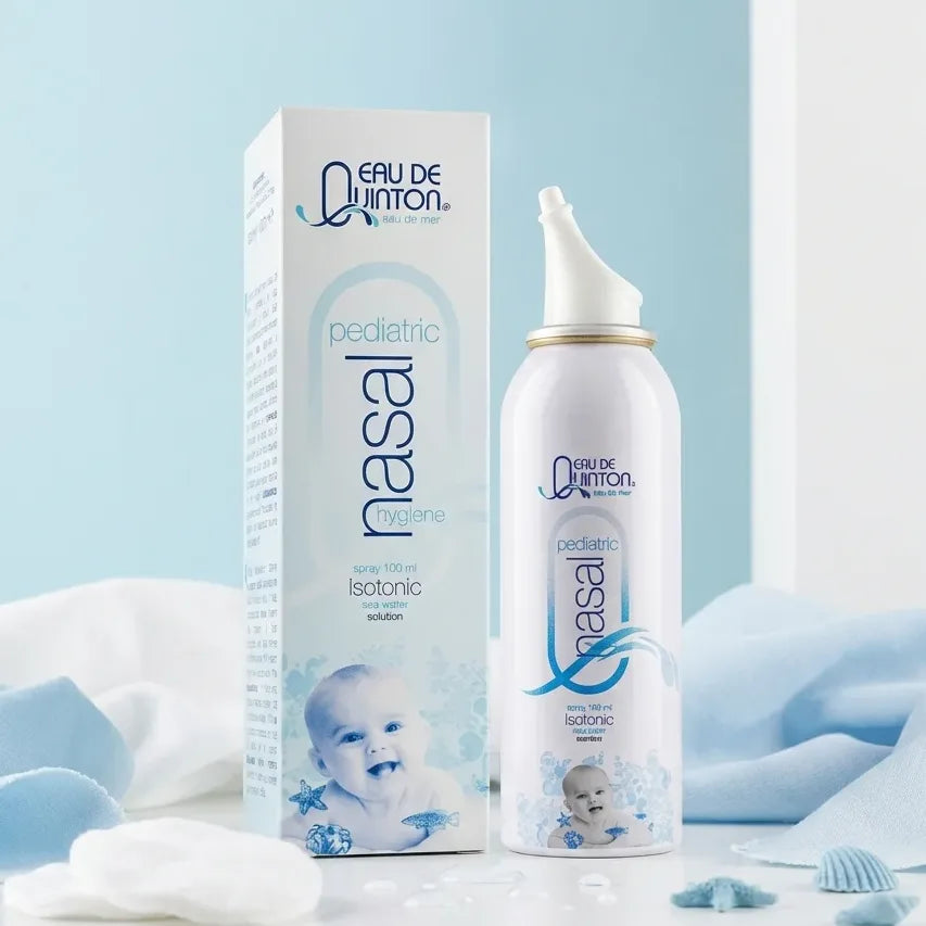 Spray Hygiène Nasal Pédiatrique Quinton 100ml sur surface blanche avec accessoires bébé