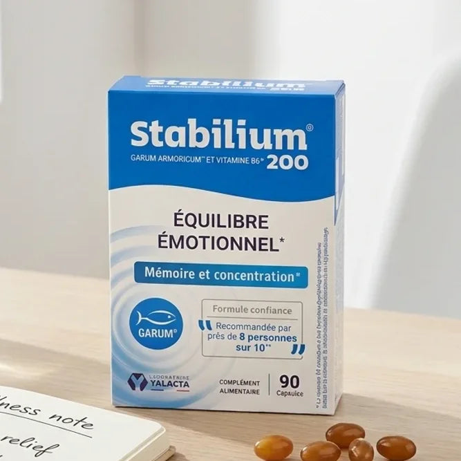 Stabilium 200 boîte bleue 90 capsules sur bureau avec verre d'eau et plante, ambiance bien-être