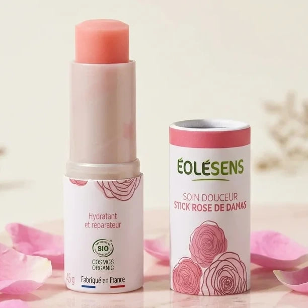 Stick à lèvres Rose de damas Eolesens sur marbre rose avec pétales de rose frais