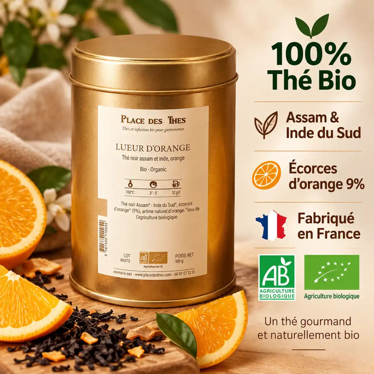 Thé noir Lueur d'Orange Bio 100g boîte dorée avec tranches d'orange et feuilles de thé sur fond bois