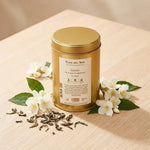 Thé vert jasmin bio Place des Thés 100g, boîte dorée avec fleurs de jasmin et feuilles de thé