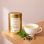 Thé vert Gunpowder Bio Place des Thés en boîte dorée avec tasse de thé et menthe fraîche