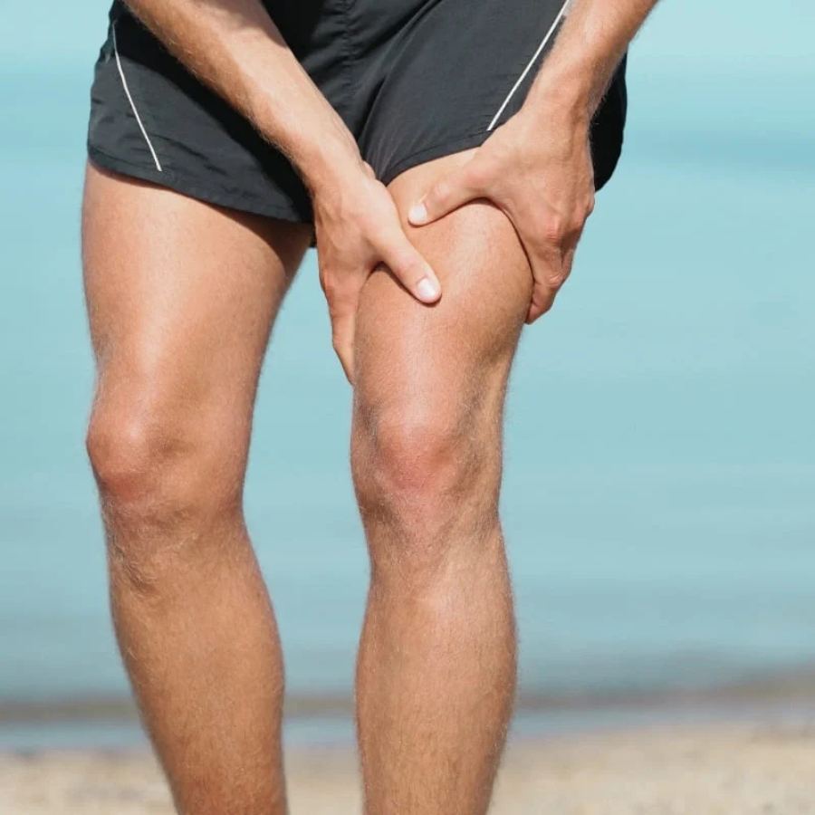 Homme appliquant une pression sur la cuisse, inconfort musculaire