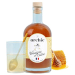 Vinaigre de cidre au miel bio Archie 500ml avec du miel en arrière-plan
