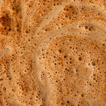 Zoom sur la mousse crémeuse et onctueuse d'un Macaccino bio nüMorning préparé dans une tasse